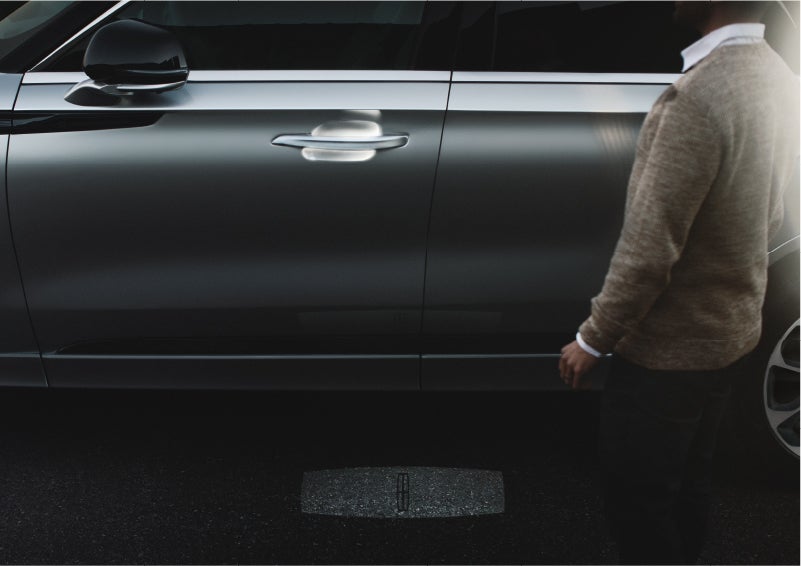 A person approaches a 2023 Lincoln Aviator® Grand Touring as the Lincoln Embrace sequence of welcome lighting illuminates | Dan Cummins Lincoln in Nicholasville KY