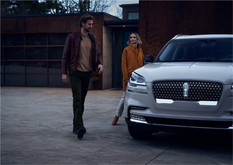 A man and a woman approaching a 2023 Lincoln Aviator® SUV, which illuminates certain lights when they are close | Dan Cummins Lincoln in Nicholasville KY