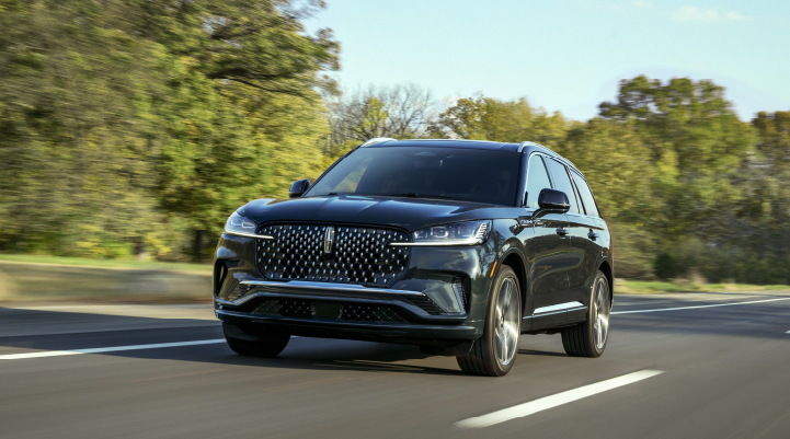 A 2025 Lincoln Black Label Aviator® SUV is being driven down a road lined with trees. | Dan Cummins Lincoln in Nicholasville KY