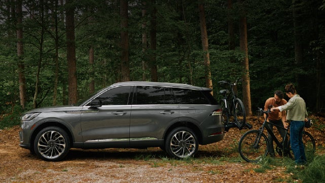 A father and son load e-bikes on a bike rack attached to a 2027 Lincoln Aviator® SUV. | Dan Cummins Lincoln in Nicholasville KY