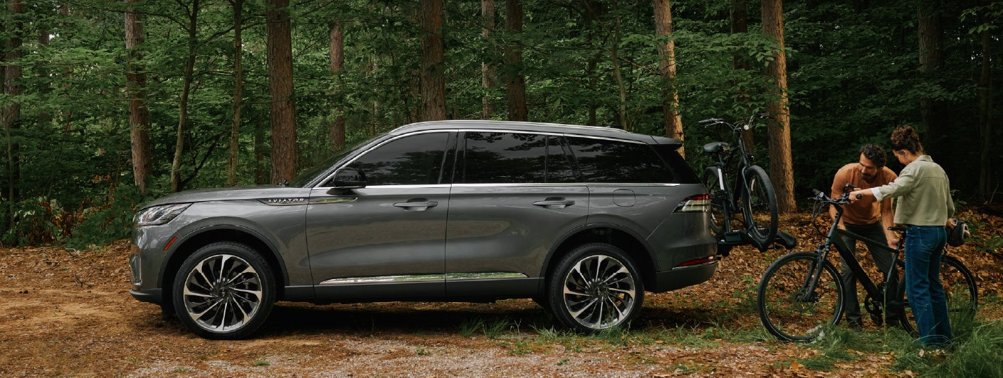 A father and son load e-bikes on a bike rack attached to a 2027 Lincoln Aviator® SUV. | Dan Cummins Lincoln in Nicholasville KY